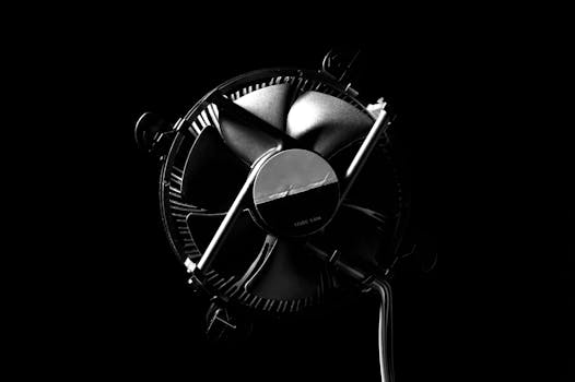 Close-up of a modern metal fan on a black background, emphasizing contemporary design.
