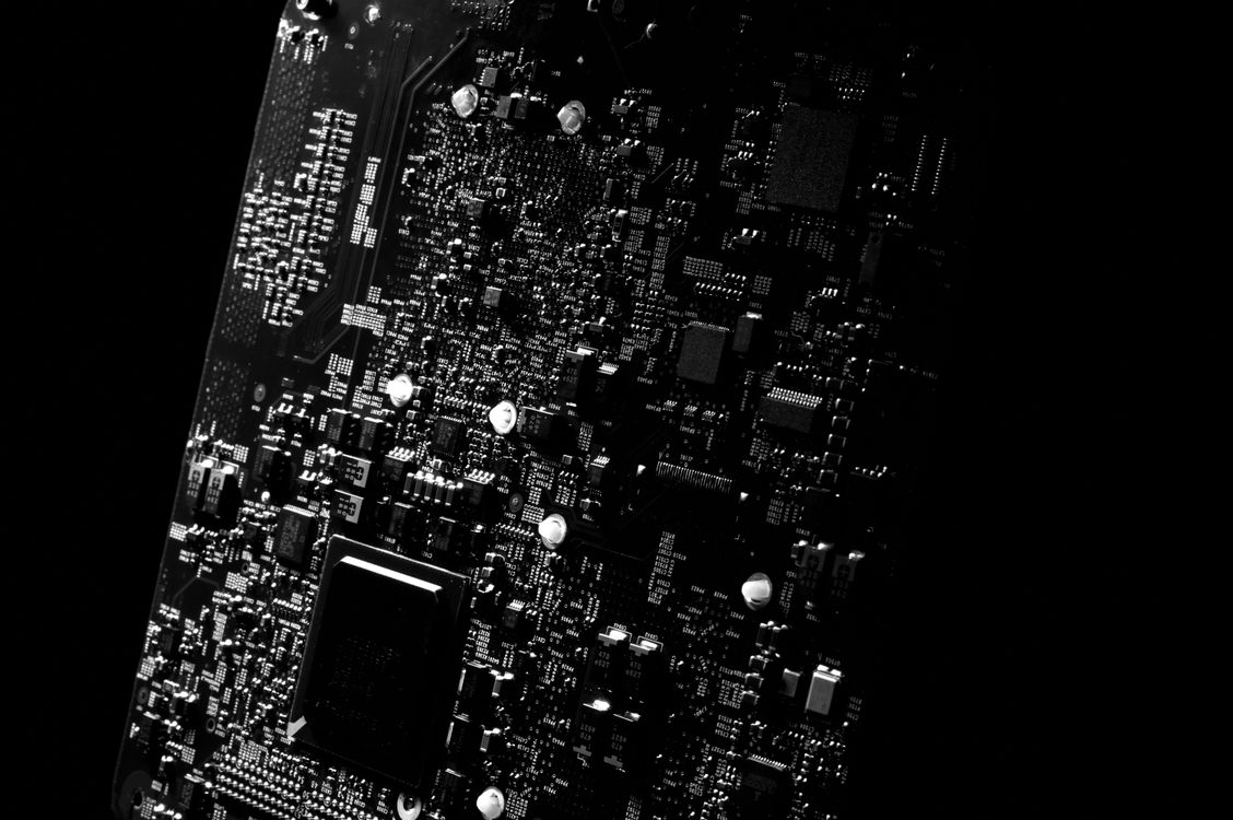 Close-up of a green printed circuit board showing intricate copper traces and soldered components — representing the open-source PCB design pipeline