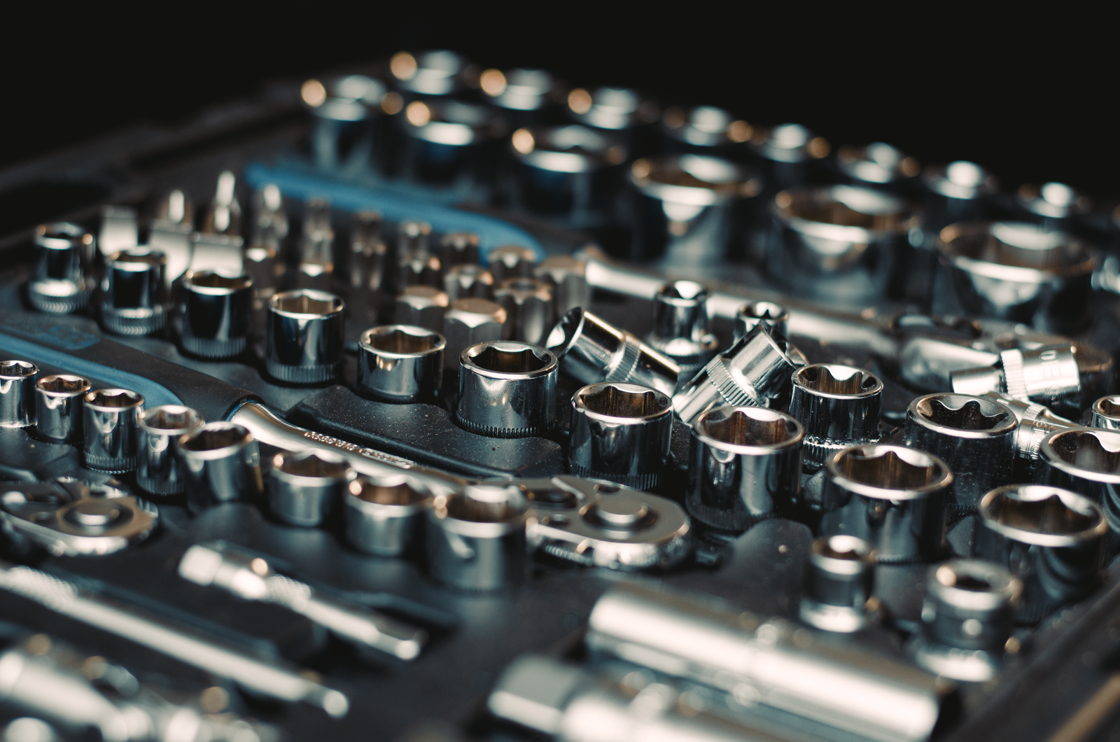 Polished chrome socket wrench set arranged in a garage tool case