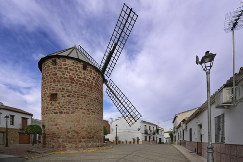 Free This image captures a historic windmill in Baños de la Encina, Andalusia under a blue sky. Stock Photo