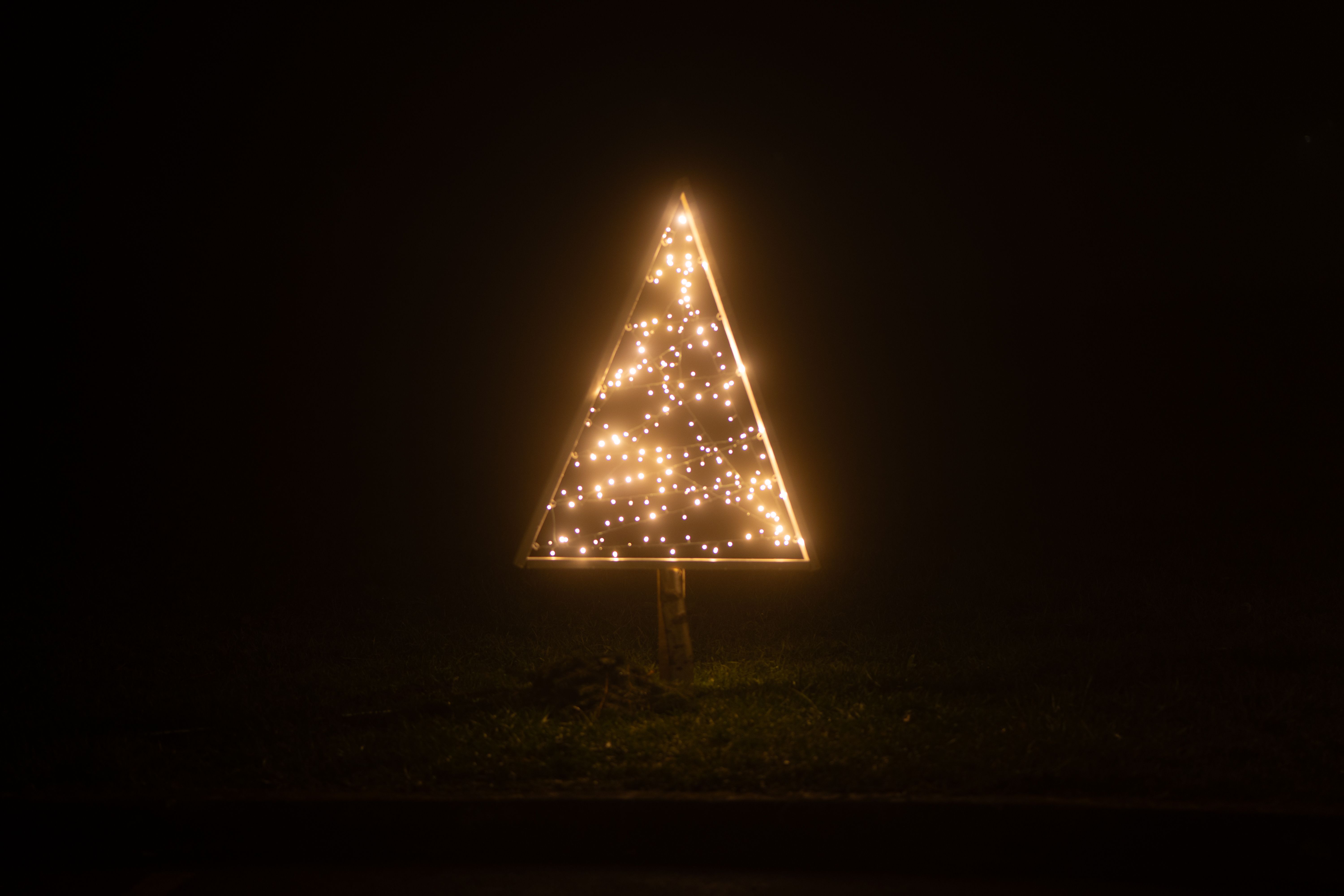 A glowing triangular light installation creates a striking visual in the dark outdoors of Garešnica,
