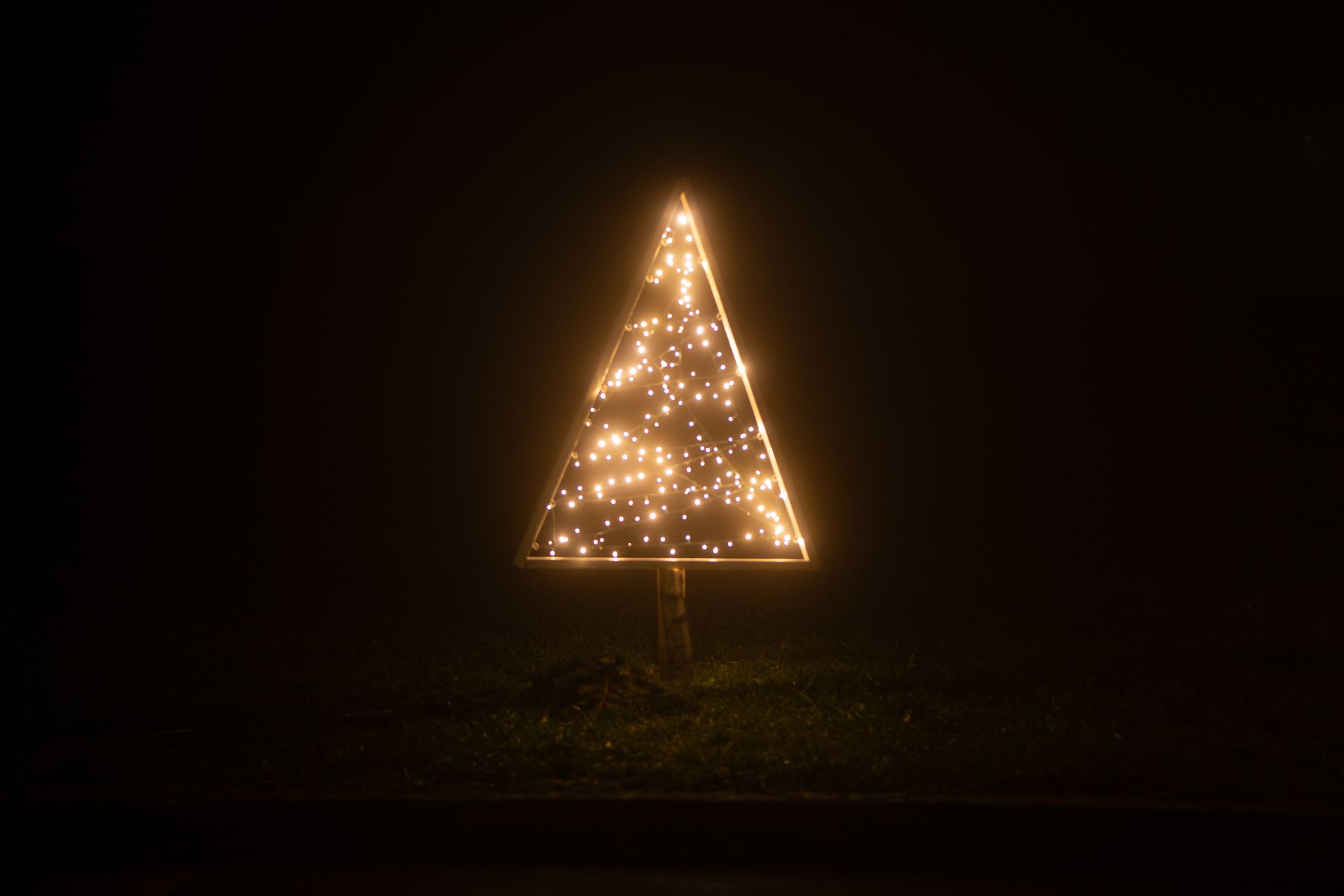 A glowing triangular light installation creates a striking visual in the dark outdoors of Garešnica,