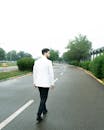 Elegant Man Walking on Empty Street in White Jacket