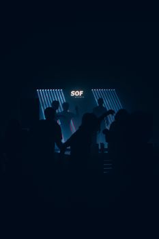 Silhouettes dance under vibrant lights in a Montreal nightclub, creating a lively nightlife atmosphere.