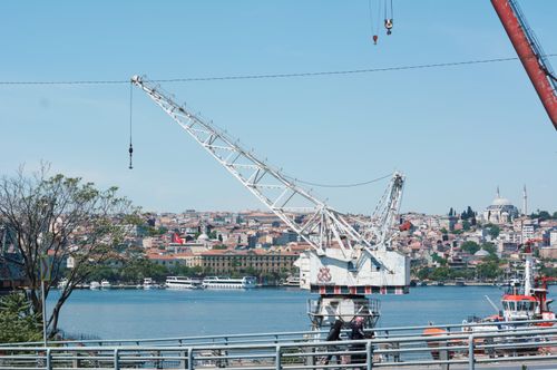 Free A scenic view of Istanbul's harbor featuring large cranes and the city skyline in bright daylight. Stock Photo
