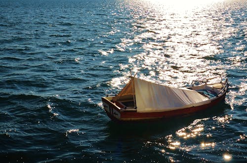 Brown Wooden Boat on Body of Water