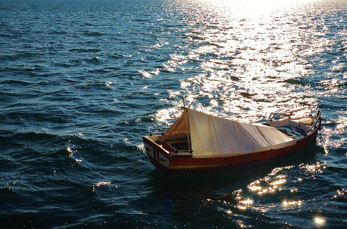 Free Brown Wooden Boat on Body of Water Stock Photo