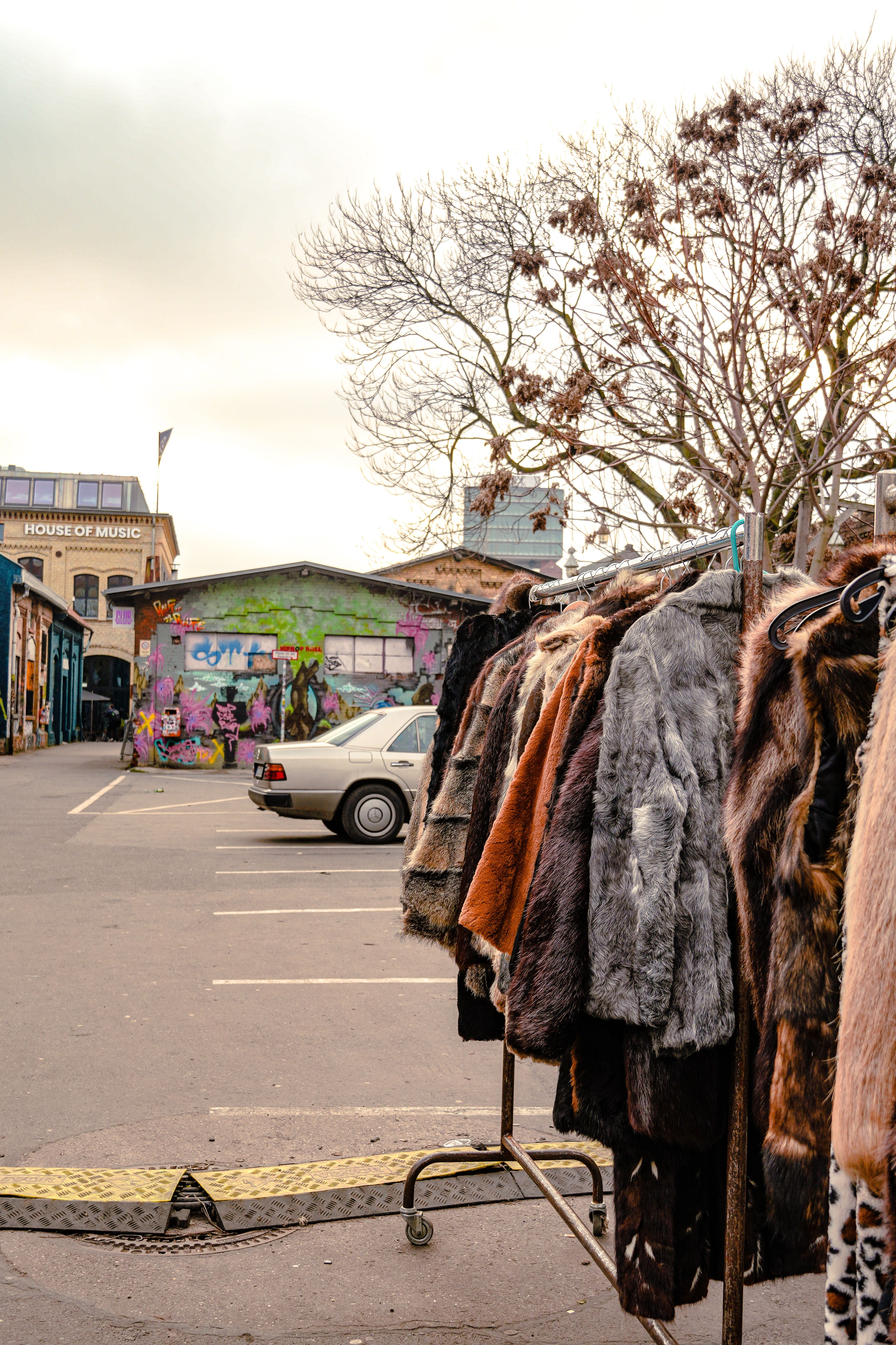 Urban Fur Coat Rack Scene in Graffiti Alley · Free Stock Photo