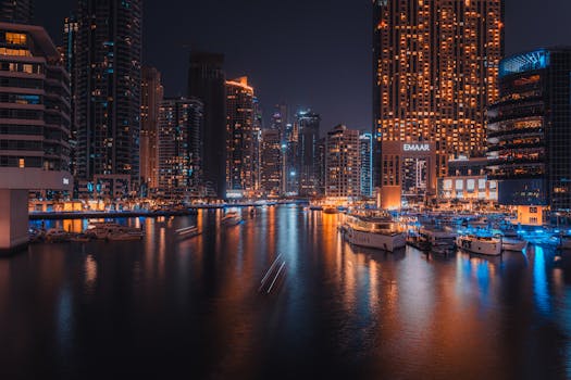 A mesmerizing long exposure photo of Dubai Marina at night showcasing illuminated skyscrapers and serene water reflections.