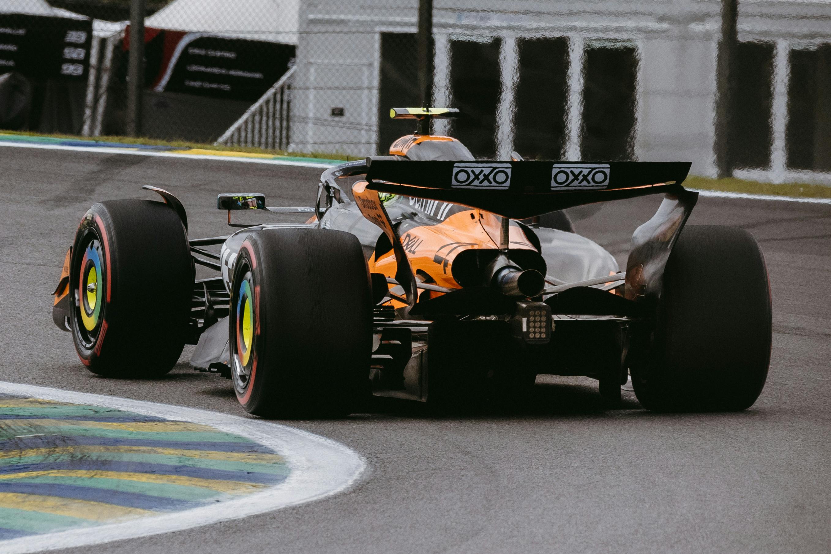 Dynamic shot of a Formula 1 car racing on a wet track in São Paulo, Brazil.