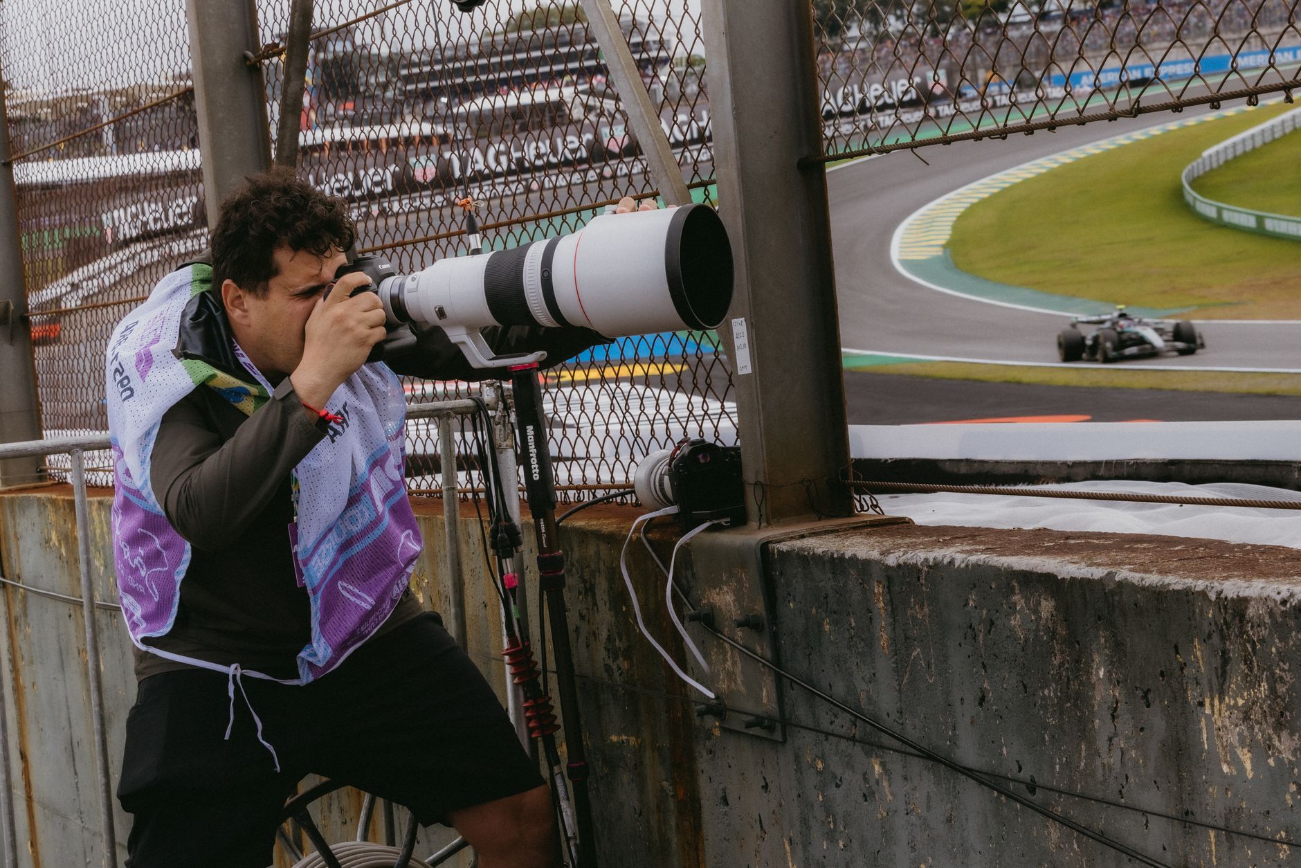 Sports photographer in action during a Formula 1 race in São Paulo, Brazil.