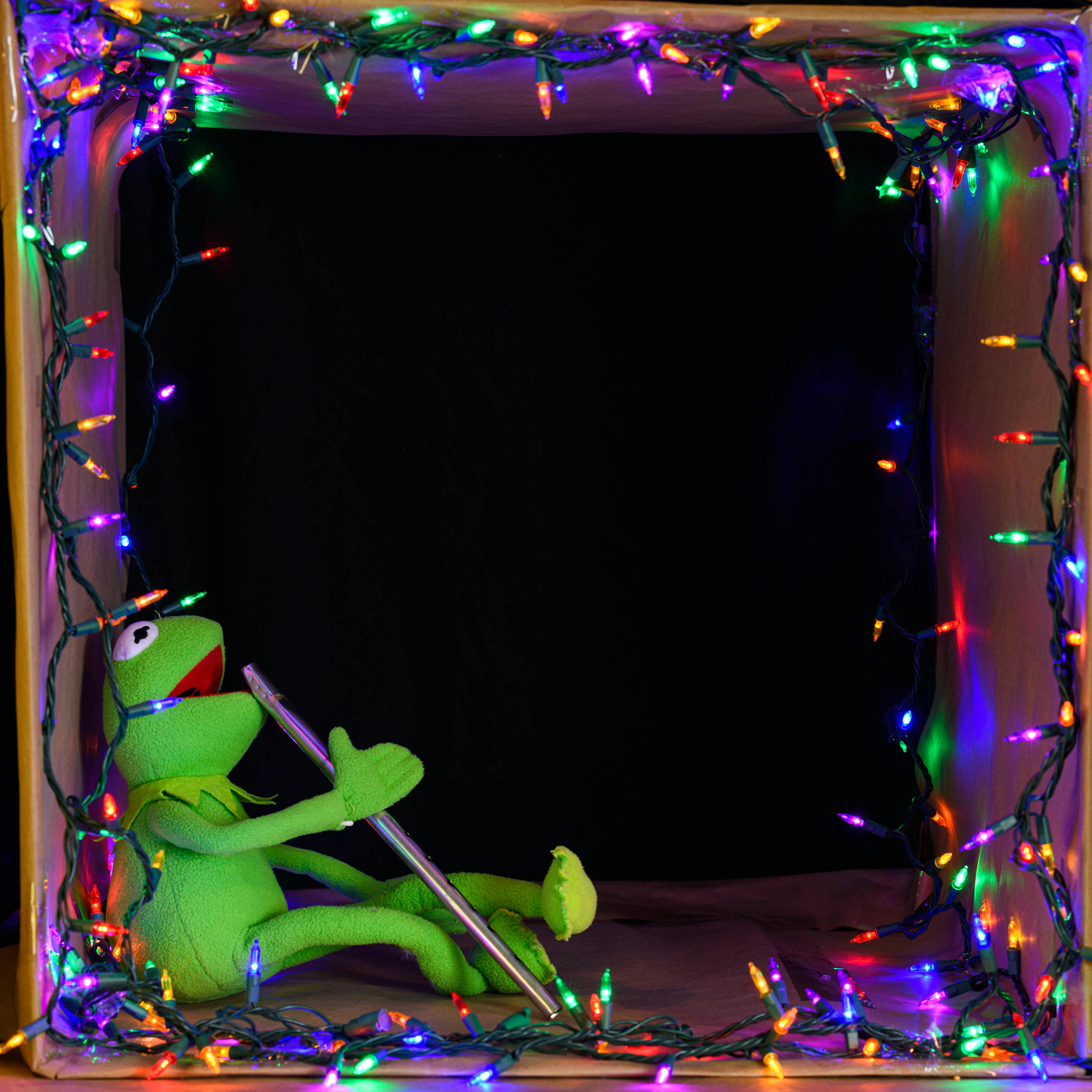 Vibrant holiday scene with a puppet holding a flute, surrounded by colorful lights.
