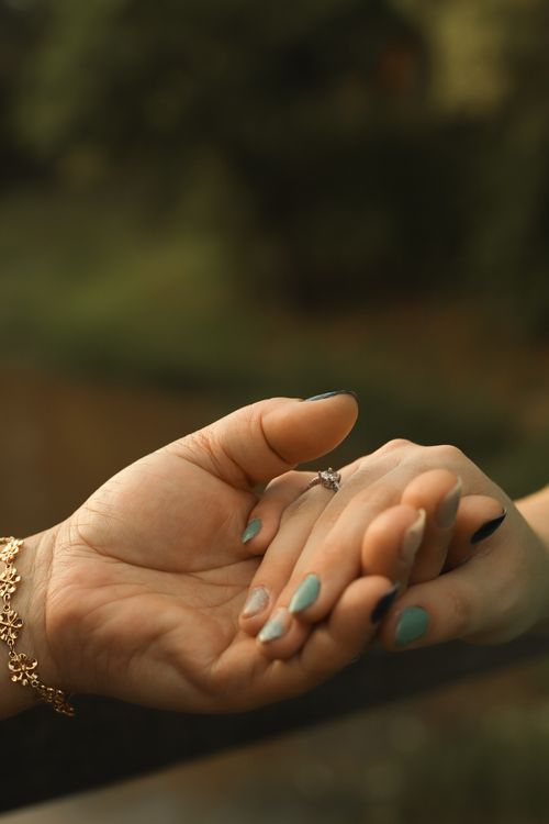 Free Close-up of a couple holding hands outdoors, symbolizing love and connection. Stock Photo