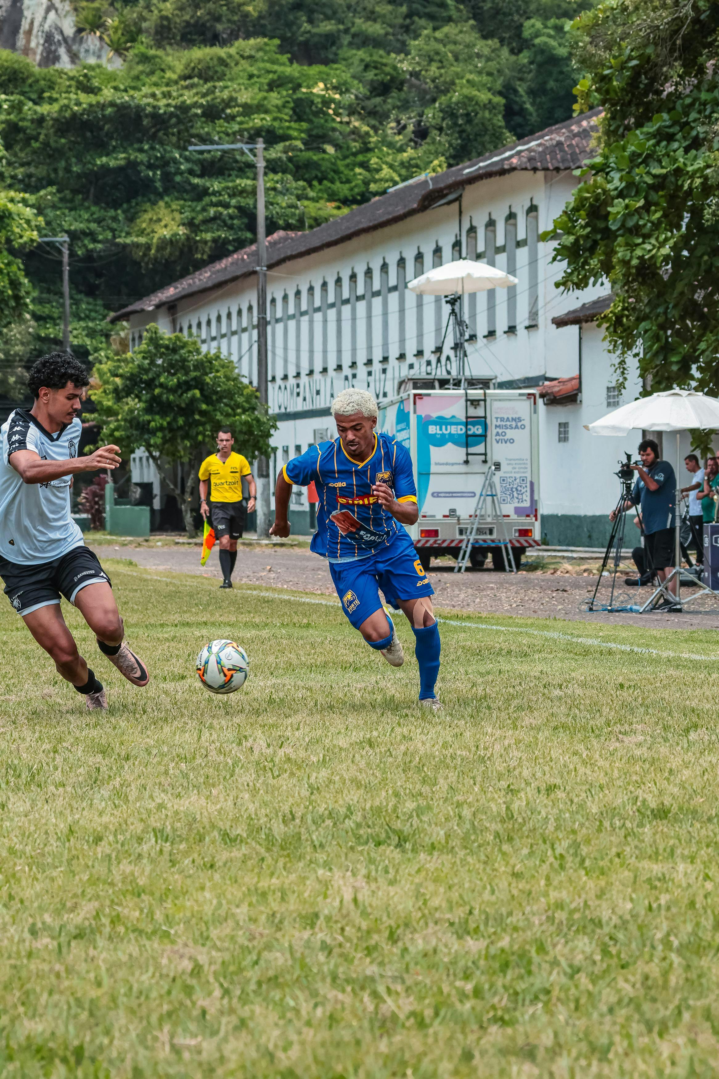 Players compete in an intense soccer match on a sunny day outdoors.