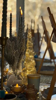 Cozy winter table setting with candles, glass decor, and warm lighting for festive gatherings.