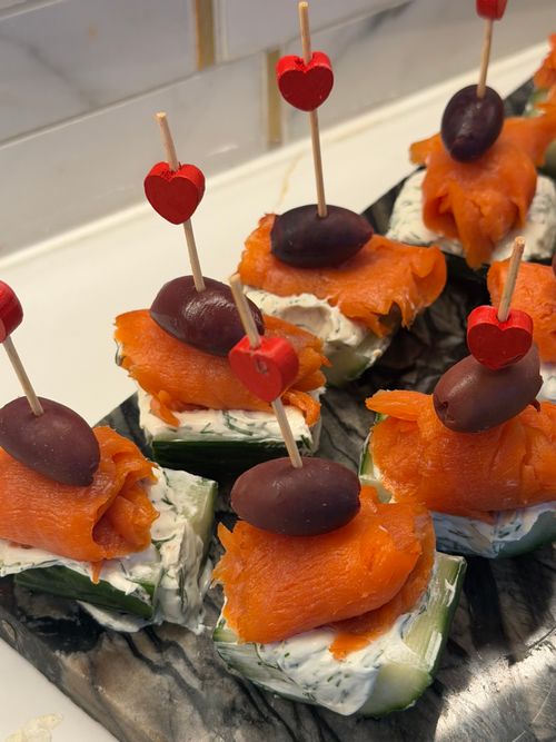 Free Elegant smoked salmon appetizers with cream cheese and olives on cucumber slices. Stock Photo