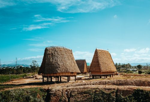 Free Traditional Rong houses under a clear blue sky in Kon Tum, Vietnam. Stock Photo