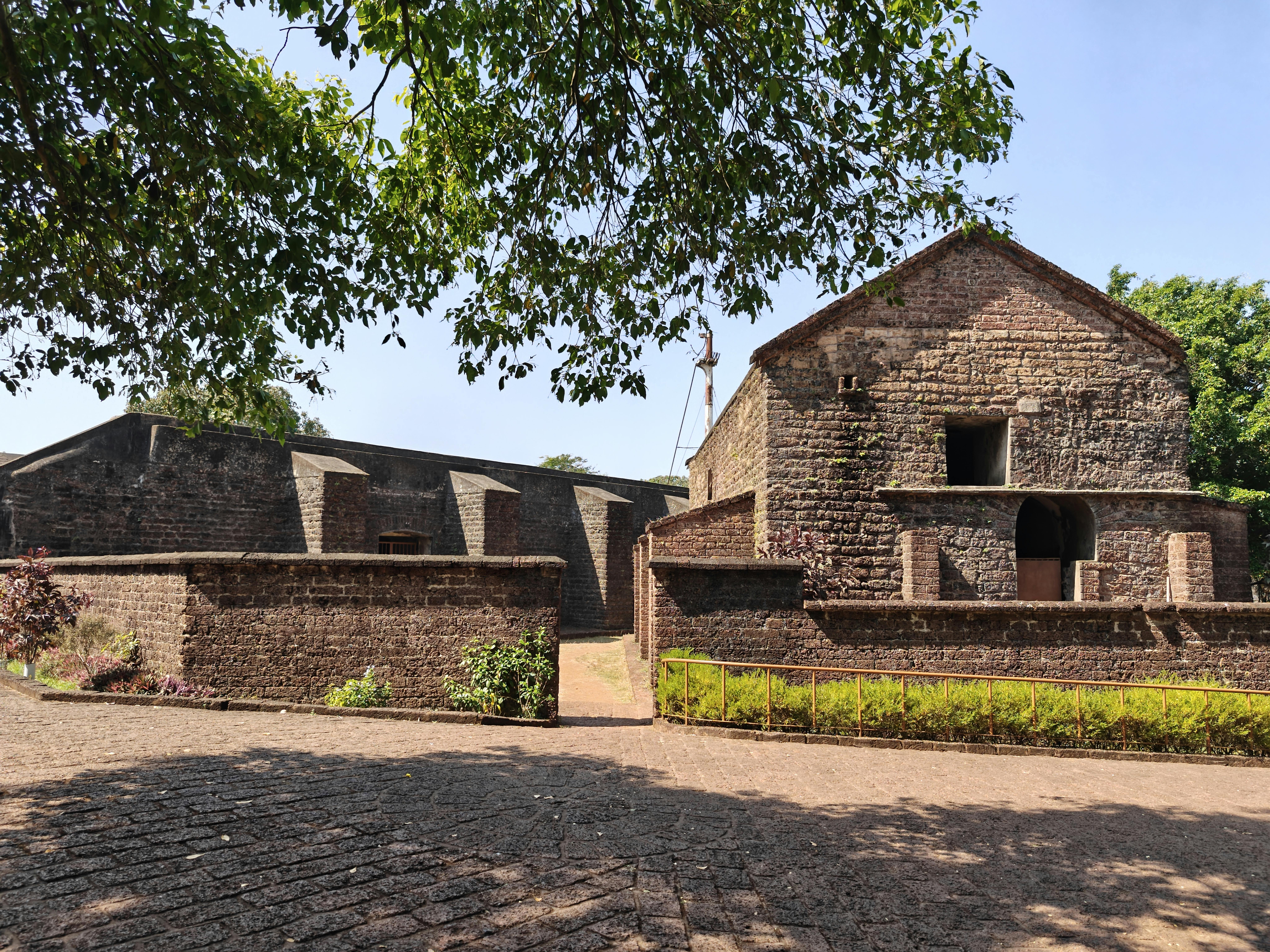 A historic view of St. Angelo Fort in Kannur, showcasing its rustic architecture under a clear, sunny sky.