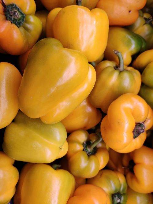 Free Close-up of vibrant yellow bell peppers stacked together, showcasing freshness. Stock Photo