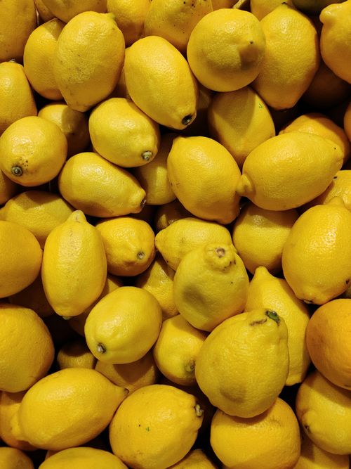 Free A pile of fresh yellow lemons captured at a market, ideal for food and nature themes. Stock Photo