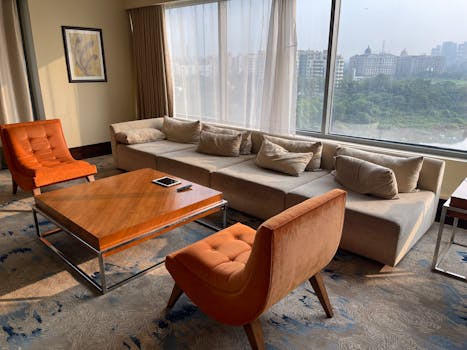 Cozy living room with elegant furniture and a city view through large windows.