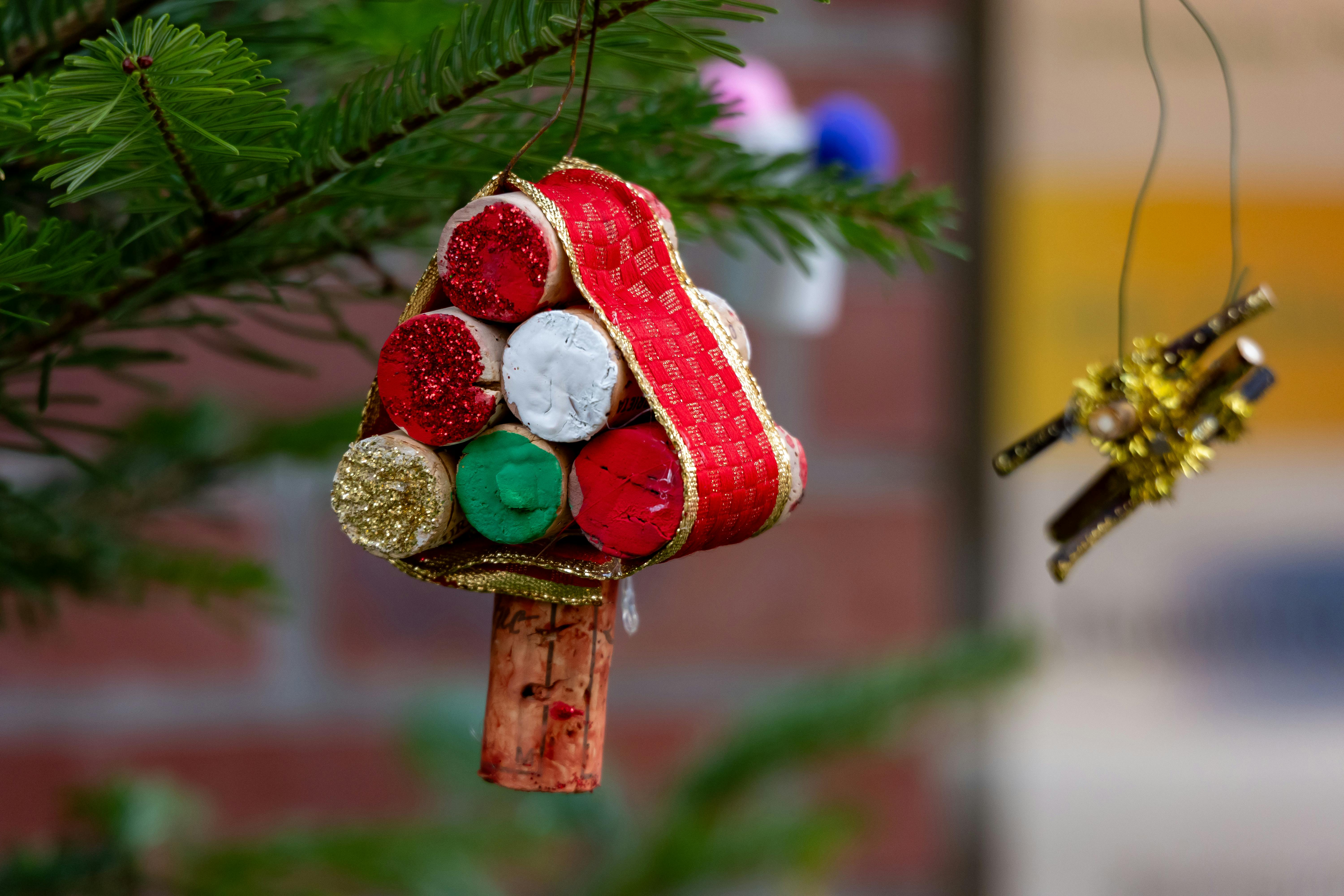 A festive handmade Christmas tree ornament made of corks and ribbon.
