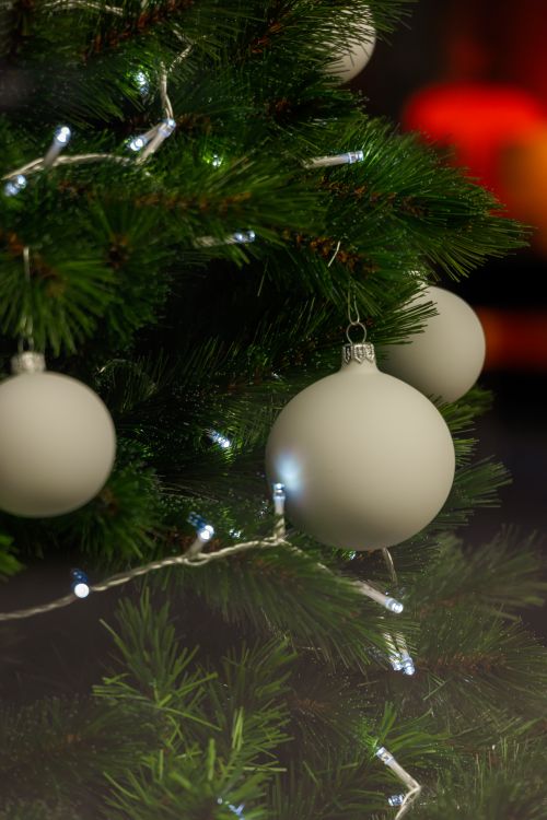 Free Decorative Christmas tree with white baubles and string lights, creating a festive atmosphere. Stock Photo