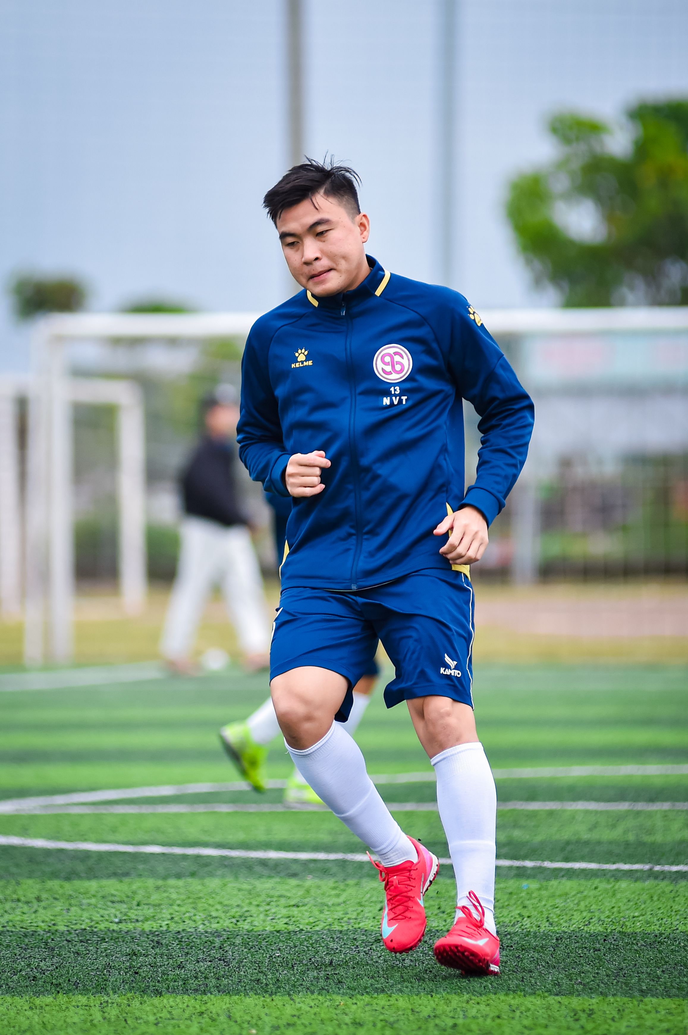 A football player running on artificial turf during training in Hà Nội, Vietnam.