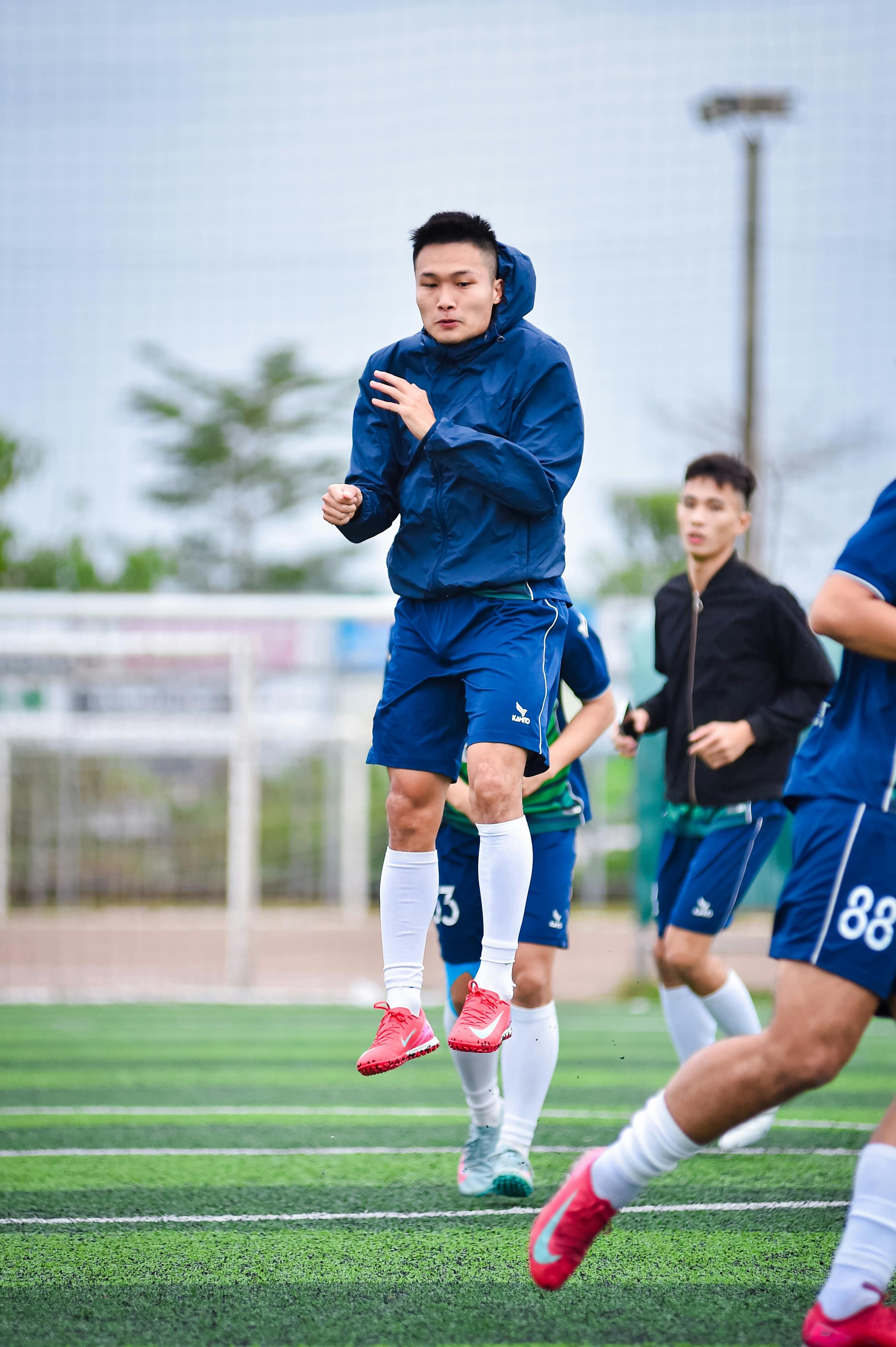 Athletic football players practicing on artificial turf in Hanoi, Vietnam.