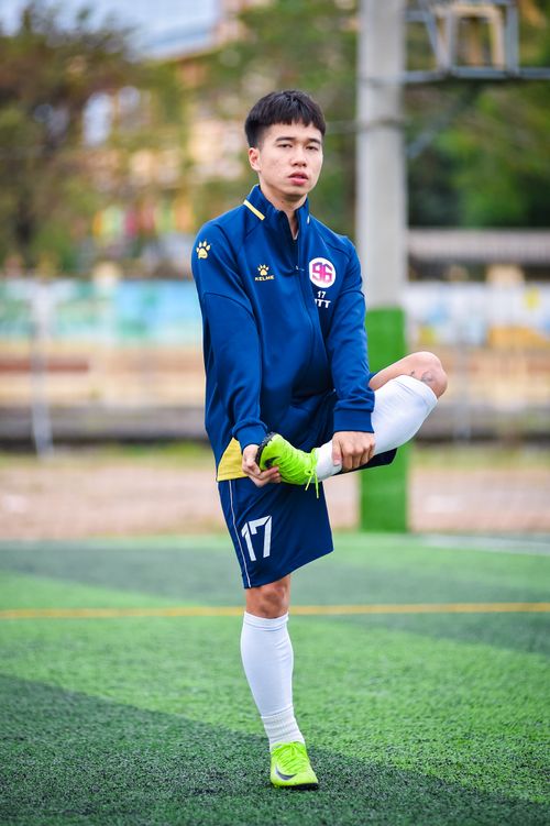 Free Young football player stretches on a field in Hà Nội, Việt Nam. Stock Photo