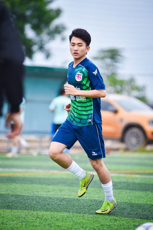 Free Asian teenager playing football outdoors on a turf field in Hanoi, Vietnam. Stock Photo