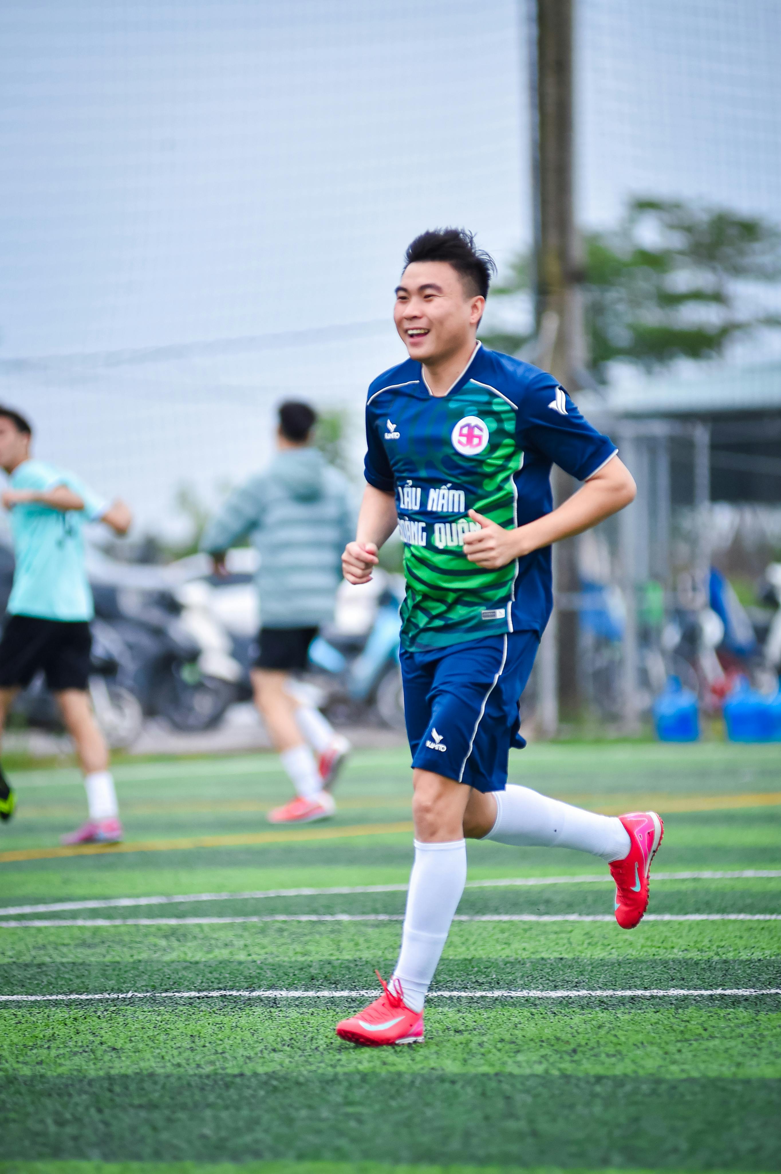 Energetic young football player smiling during a match in Hà Nội, Việt Nam.