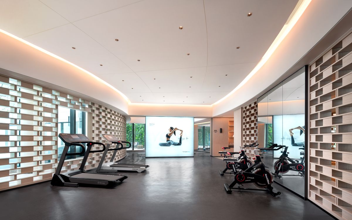 Sleek gym interior with treadmills and stationary bikes, technology-focused design.