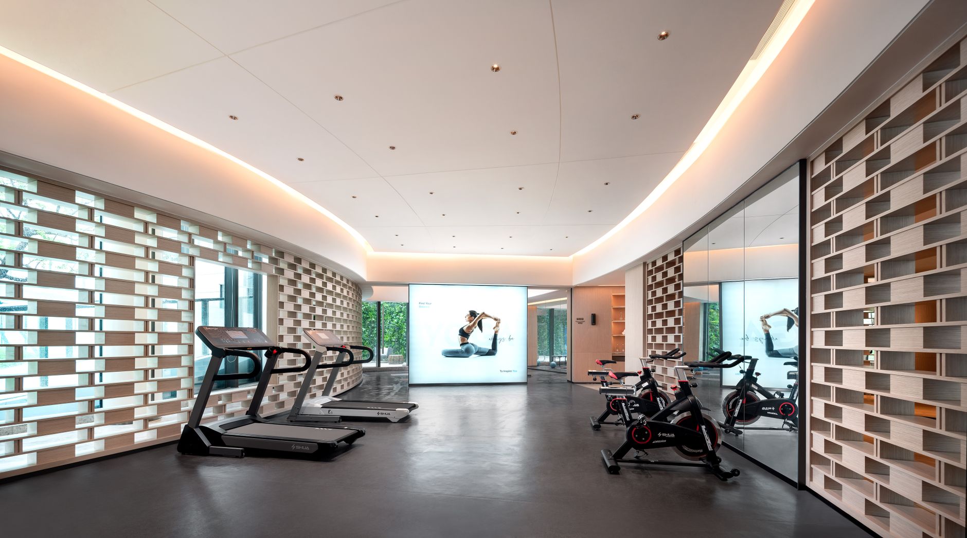 Sleek gym interior with treadmills and stationary bikes, technology-focused design.