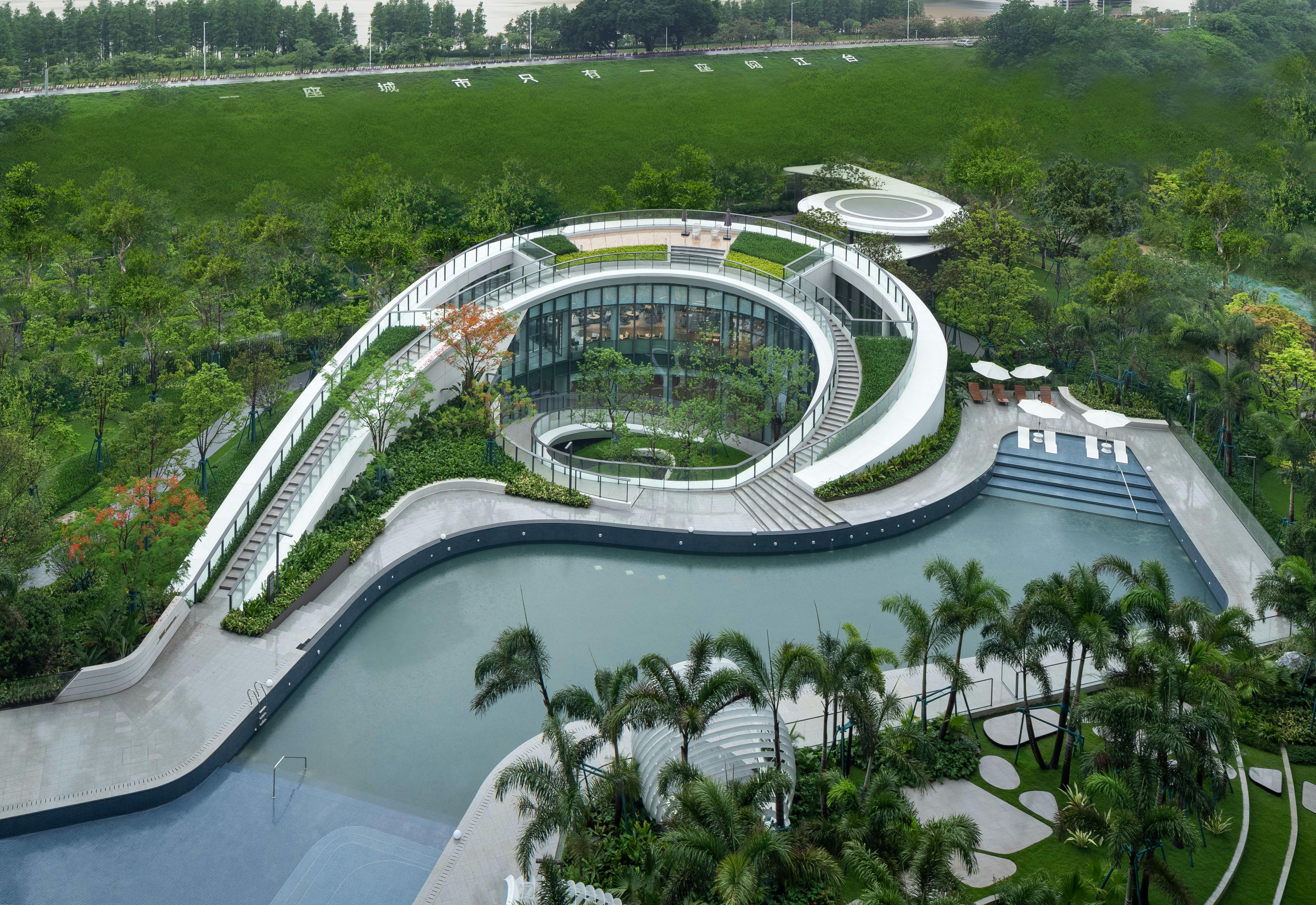 Aerial view of a unique spiral architectural structure in a lush tropical park.