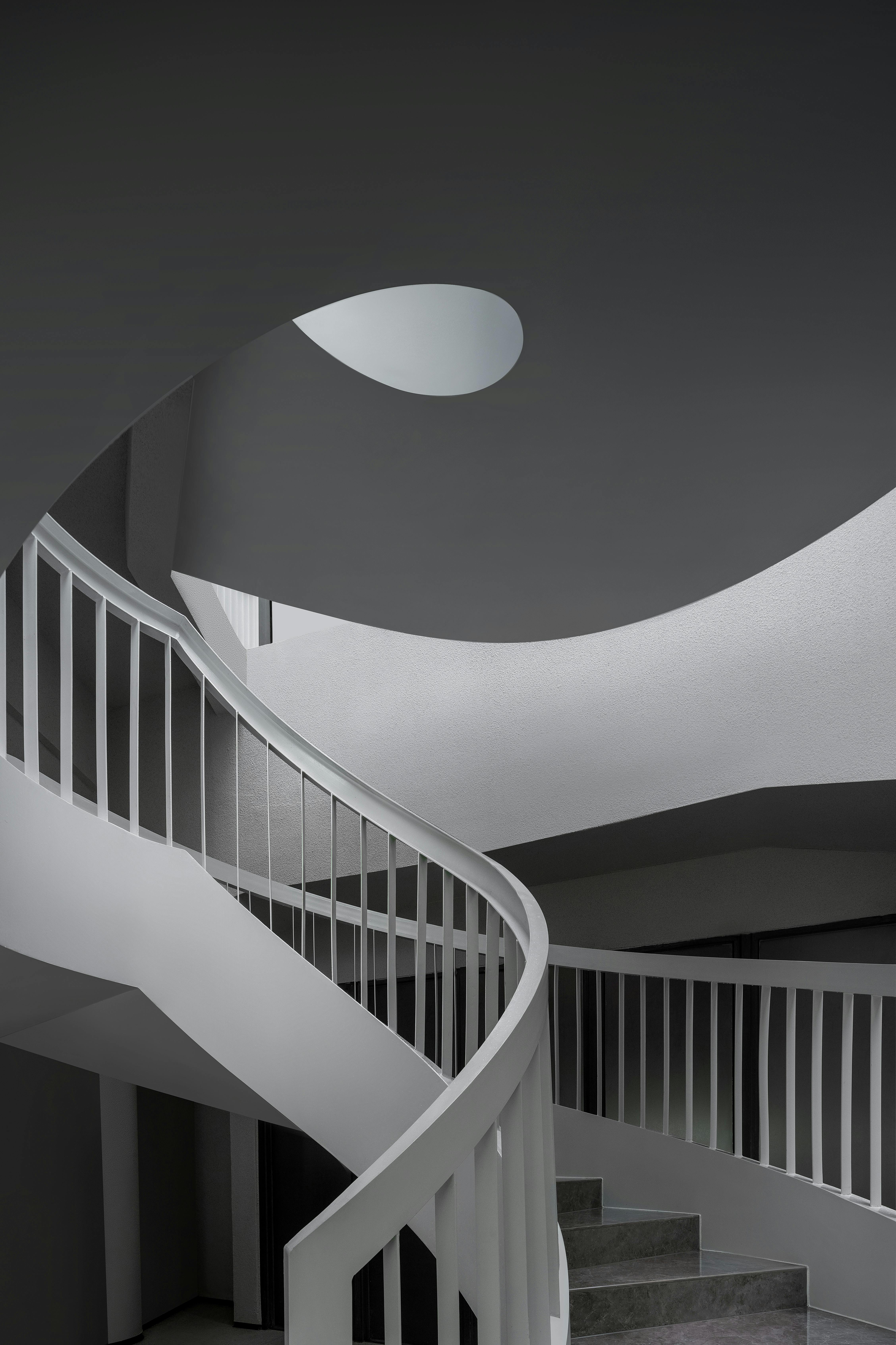 Sleek spiral staircase in modern architecture with minimalist design and natural lighting.