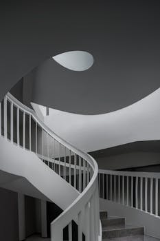 Sleek spiral staircase in modern architecture with minimalist design and natural lighting.