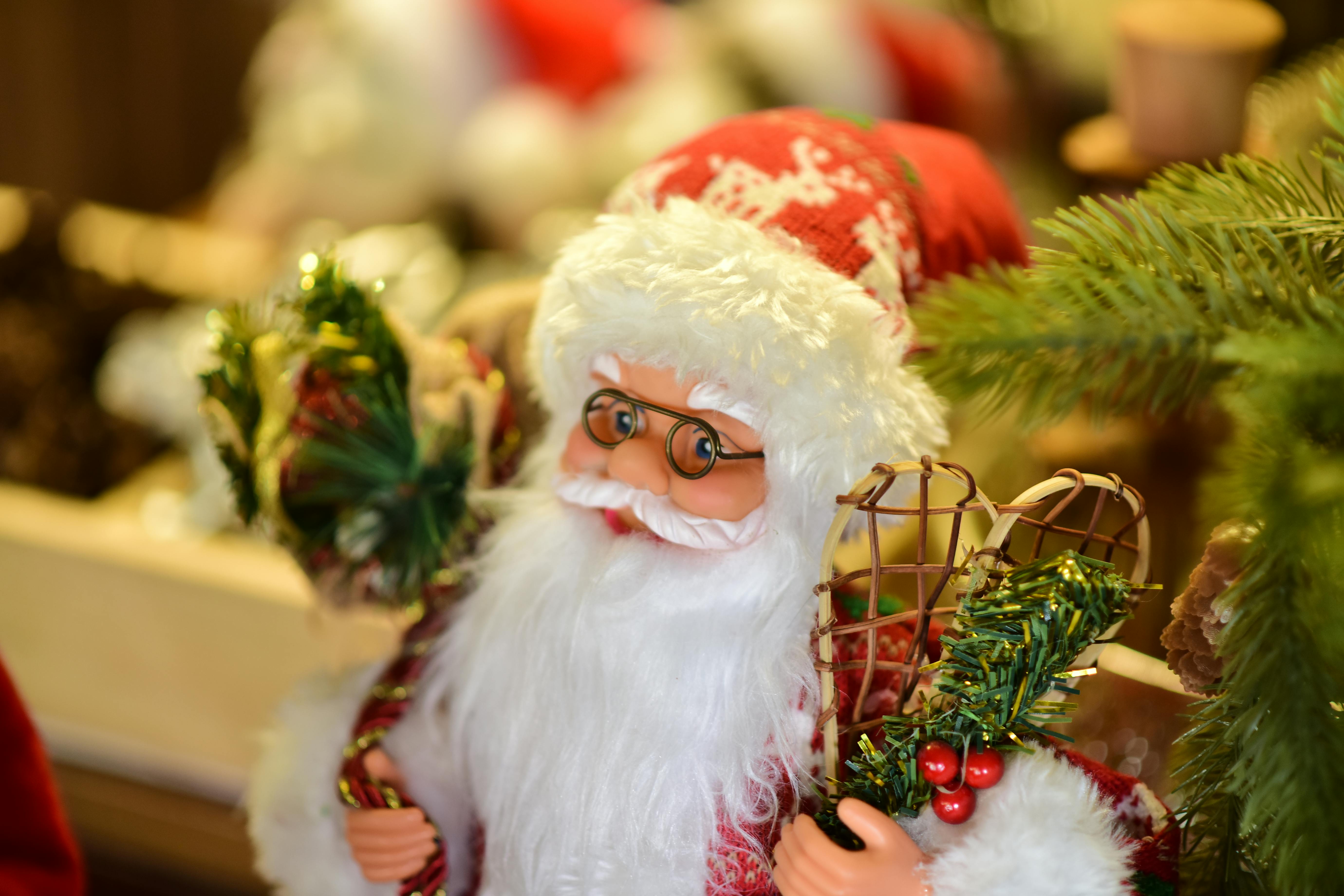 Close-up of a Santa Claus figurine holding festive gifts, embodying Christmas spirit.