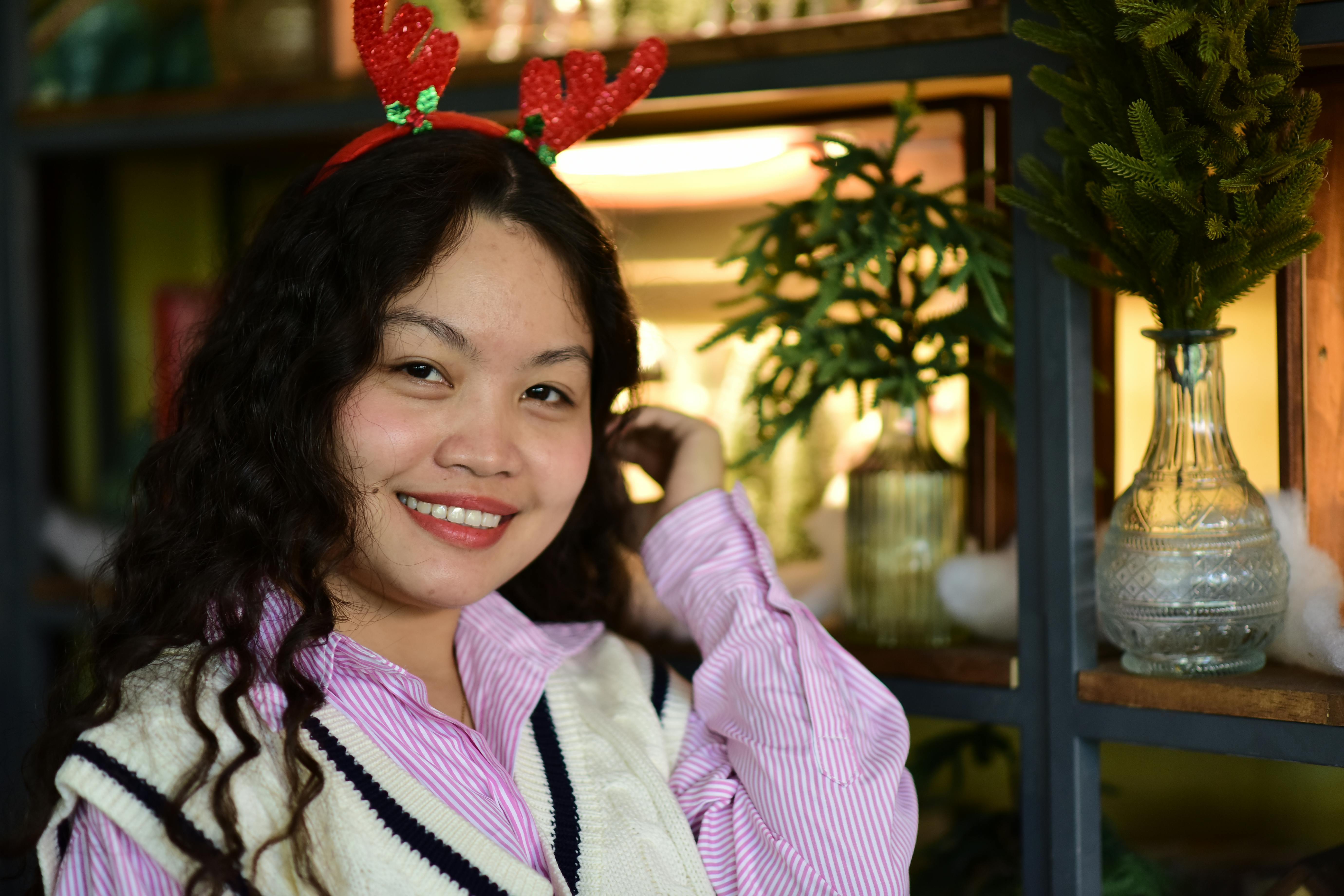 De franc Dona alegre amb banyes de ren posant a l'interior amb decoració nadalenca. Foto d'estoc