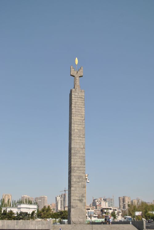 Free A towering monument stands against a clear blue sky in an urban setting, showcasing architectural beauty. Stock Photo
