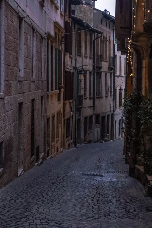 Free Cozy cobblestone street with old-world charm, illuminated by string lights. Stock Photo