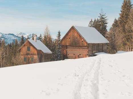Rustic wooden chalets in a snowy winter landscape in the Austrian Alps.
