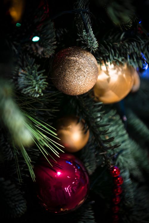 Free Close-up of Christmas ornaments on a beautifully decorated tree capturing festive spirit in Dubai. Stock Photo