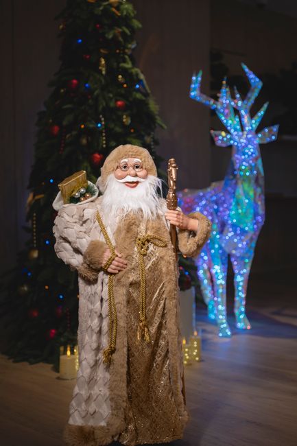 Santa Claus decor near a Christmas tree and illuminated reindeer in Dubai ambiance.