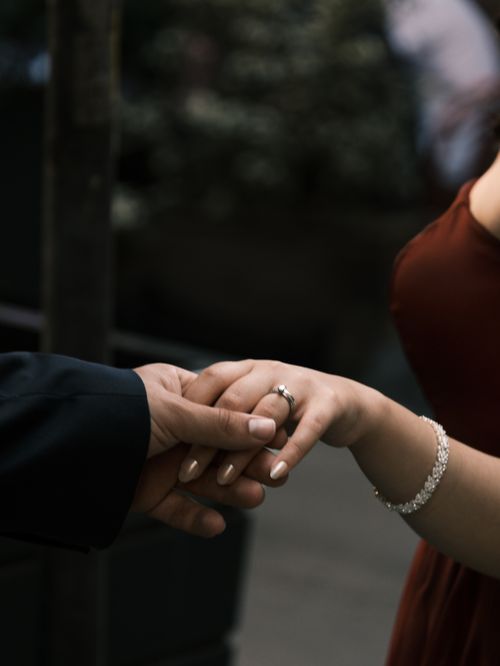 Free A close-up of a couple holding hands, displaying wedding rings and love. Stock Photo