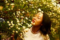 一位戴眼镜的年轻女子在花园里欣赏盛开的白色花朵