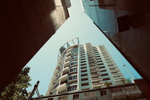 Upward view of a contemporary high-rise building against a clear sky.