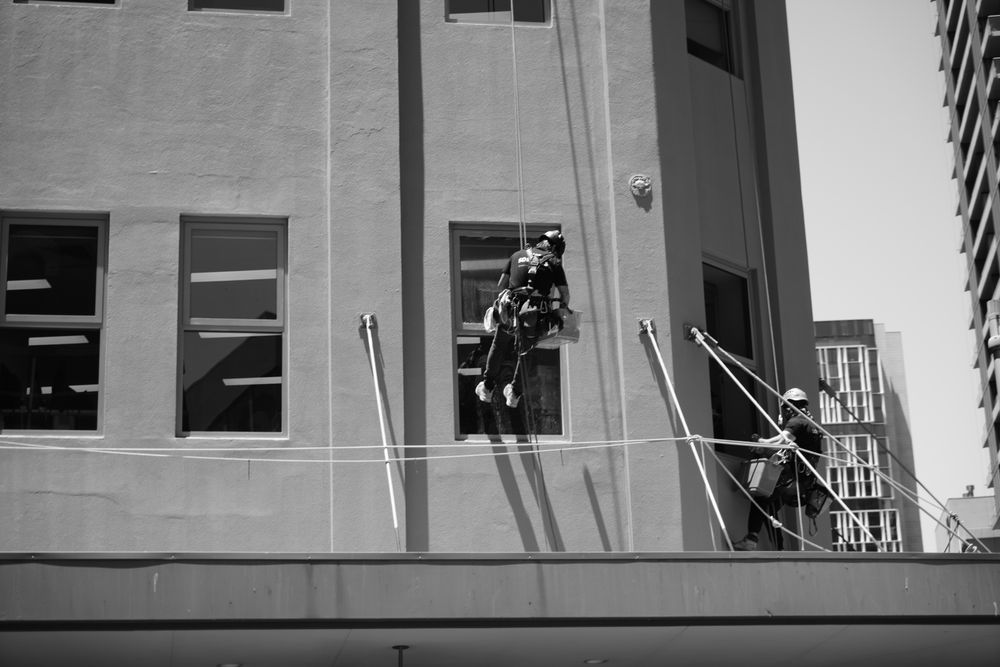Professional window cleaners on a high-rise building exterior