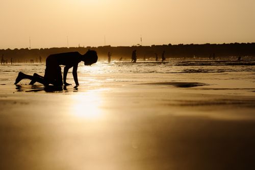 Free Silhouette of a child playing on the beach at sunset in Rabat, Morocco. Perfect for travel and lifestyle images. Stock Photo