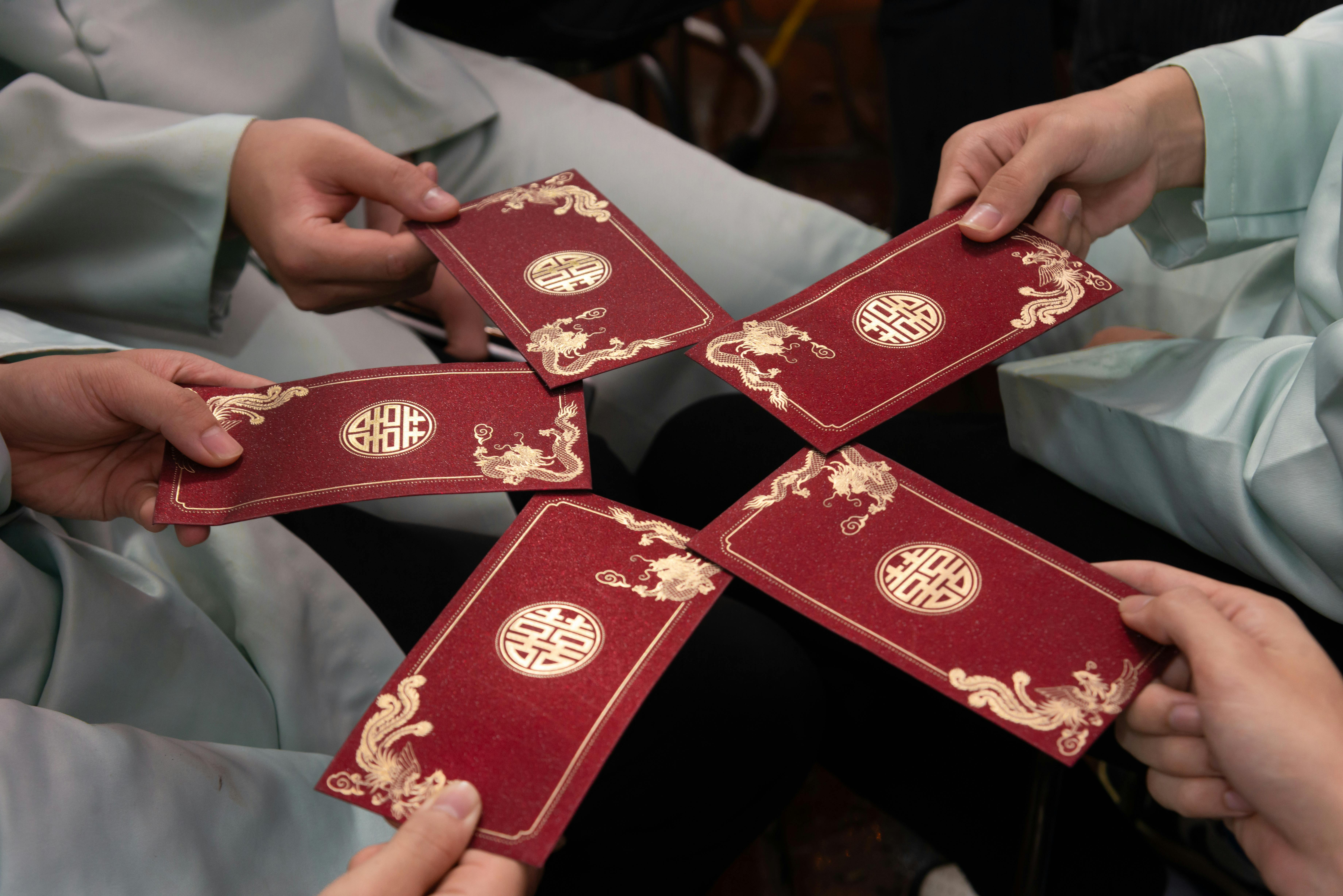Group of people exchanging red envelopes symbolizing prosperity and good fortune.